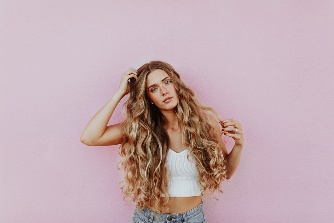 woman-standing-next-to-pink-wall-while-scratching-her-head-4nulm-juyfo